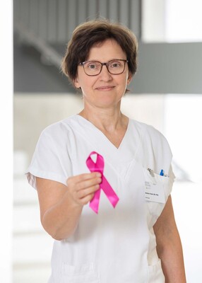 Foto: Foto Muik Andrea Fassl, BSc, Diätologin, mit rosa Schleife in der rechten Hand