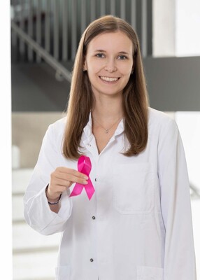 Foto: Foto Muik Aylene Schmidt, BA MA, Medizinische Organisationsassistentin, mit rosa Schleife in der rechten Hand