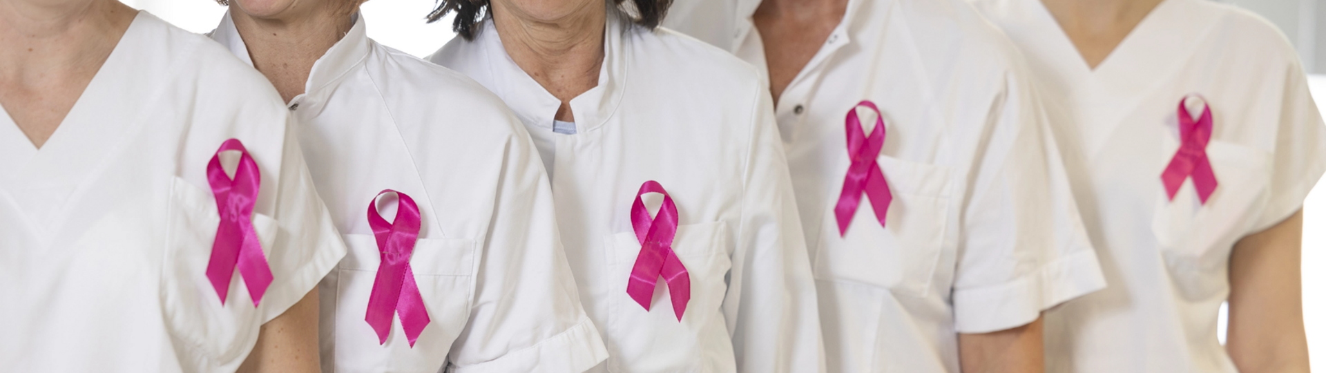Foto: Foto Muik 5 Frauen in weißer Dienstkleidung mit rosa Brustkrebs-Schleife